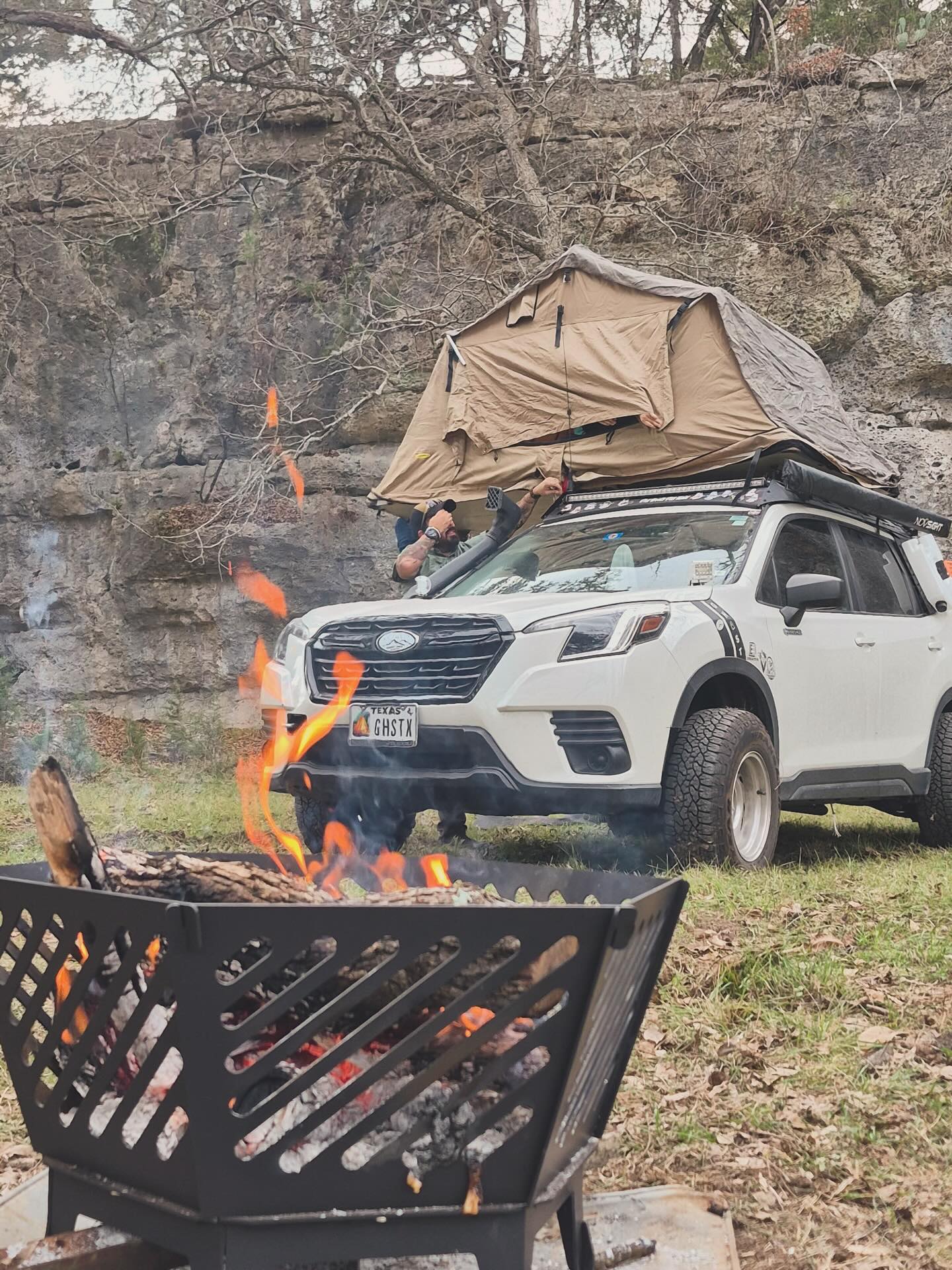 Camp set up, fire going, tent up top — same routine, wherever we park the Ghost