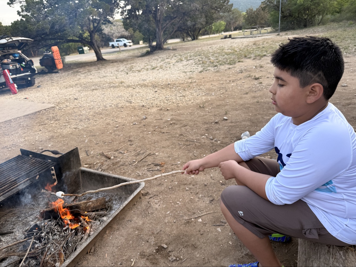 Jonah roasting a marshmallow at camp — the little moments are the ones that stick